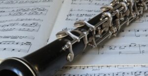 An used oboe laying on a music sheet