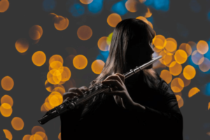 Flute player performing with lights behind