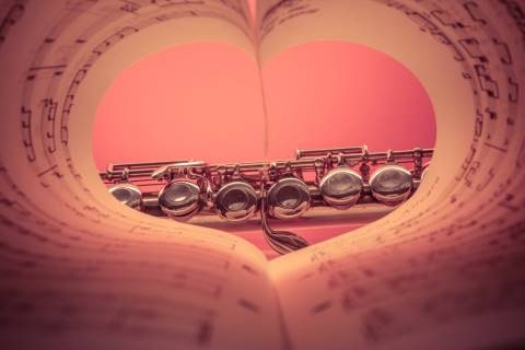 Heart-shaped music sheet with a flute in front