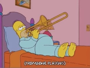 Homer Simpson plays a trombone lying on bed