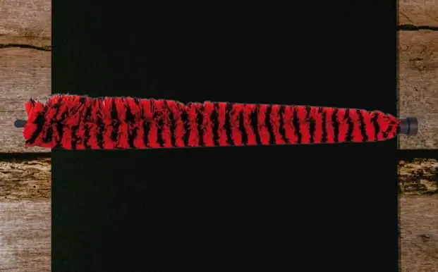 A red colored sax pad saver on a black background