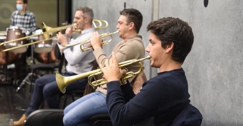 Two trumpet players and one trombone player performing