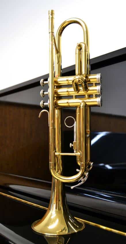 a brass trumpet above a piano 1